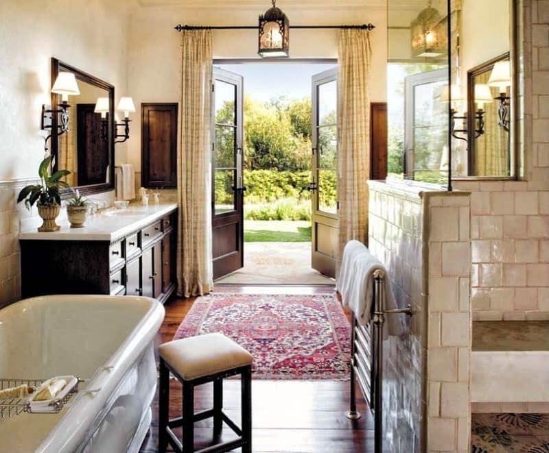 towel warmer in polished chrome finish and white bathtub with tray and porcelain tiles in running bond pattern for shower area walls and oriental area rug on polished hardwood floors and black lantern pendant light
