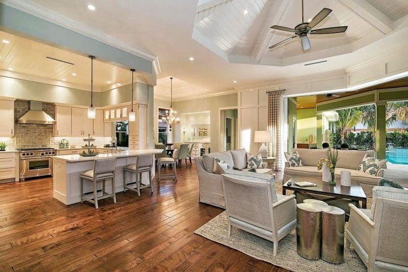 matching light gray counter chairs and sofas with beadboard paneled kitchen ceiling and living room octagonal ceiling with gray marble tile backsplash and medallion with metallic spray painted clover leaf-inspired side table