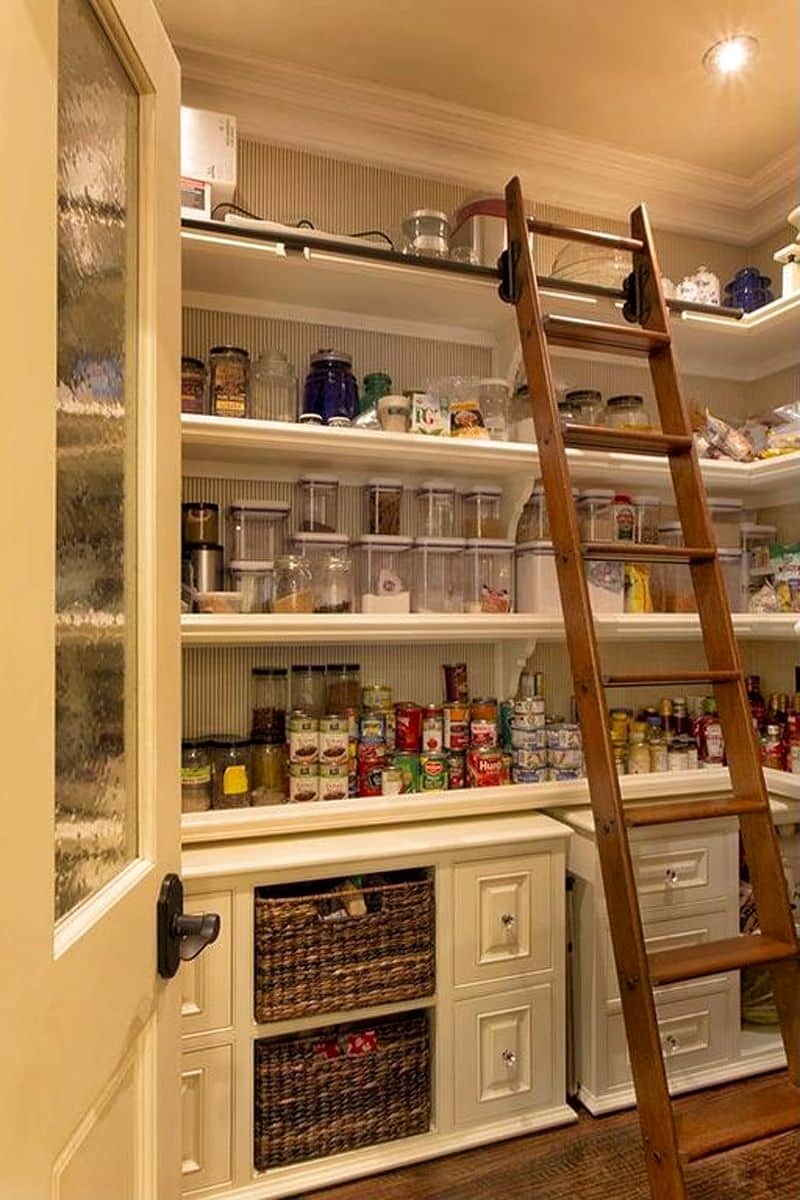 textured glass walk-in pantry door with oil-rubbed bronze handle and eggshell white drawers with raised panels and crystal glass knobs and eggshell white shelves with striped rear wall and rolling wooden library ladder
