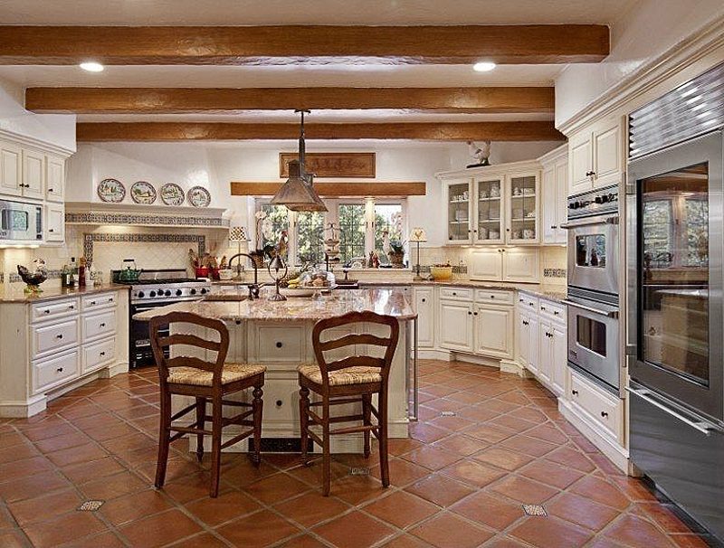 diamond pattern terracotta flooring with pebble accent and matching backsplash accent and range hood mantle trims with exposed wooden beams matching window trim panels
