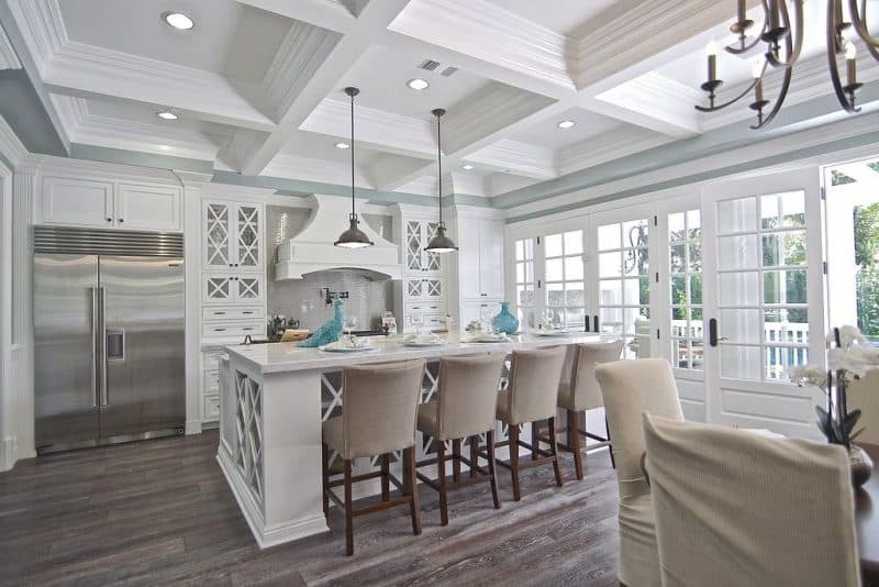 10-lite over 1 raised wood paneled French doors and X mullion glass upper cabinets with metallic mosaic stove backsplash and palladian blue walls with whitewashed staggered hardwood floor