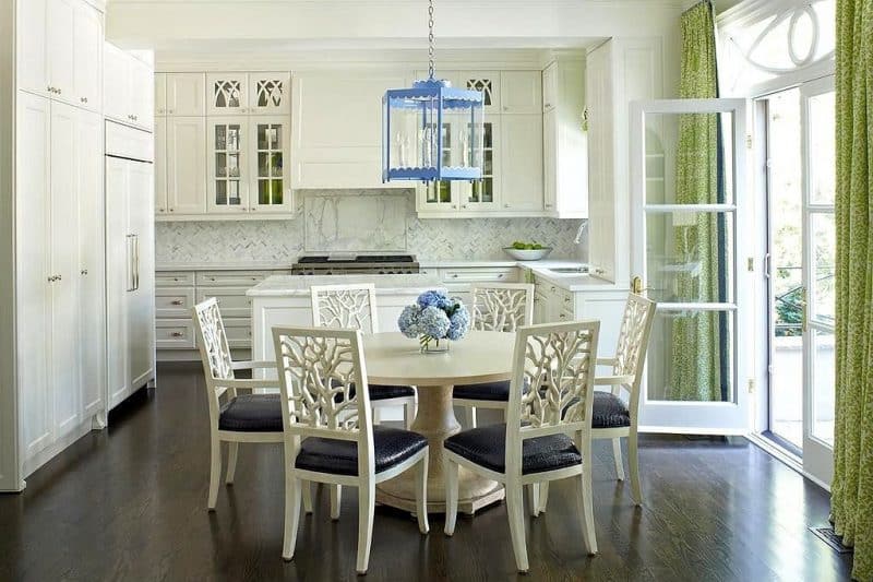 3-panel in-swing French doors with L-shaped white quartz countertop with herringbone marble mosaic tile backsplash and large baby blue hexagonal lantern pendant light with white tree branch style dining chair backrest