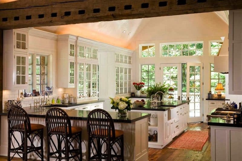 white French doors in matching windows above countertop with mirrored cabinetry with above-cabinet lighting and black quartz countertops with modern shaker base cabinets with reclaimed timber beam with square holes